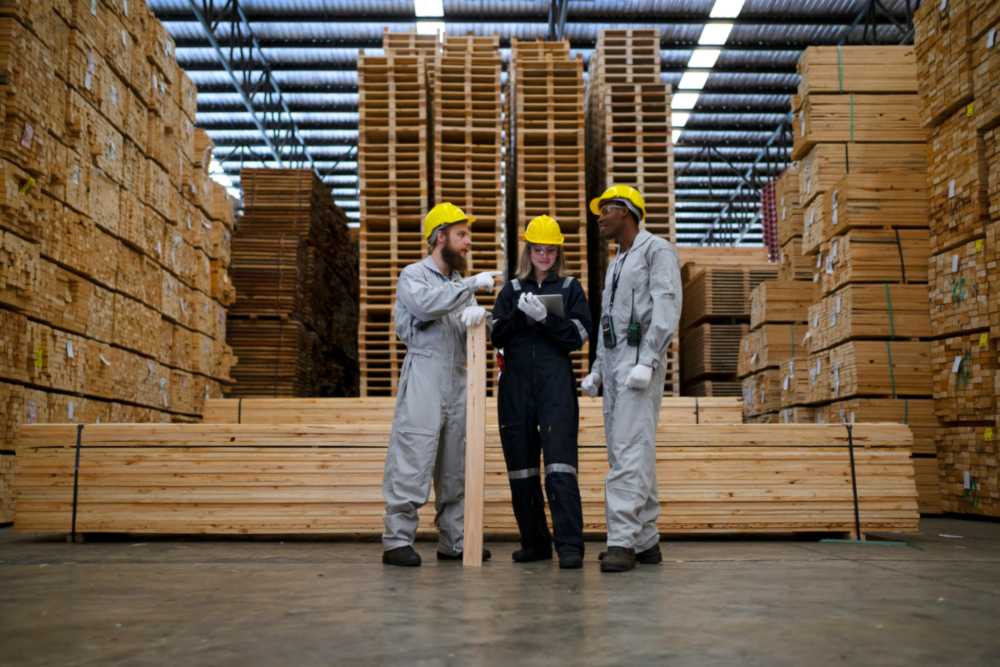 Workers inspecting wooden pallets in warehouse for ISPM 15 compliance